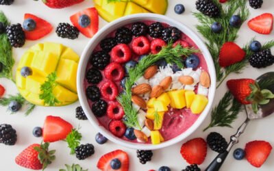 Fruit filled breakfast bowl surrounded by more fruit