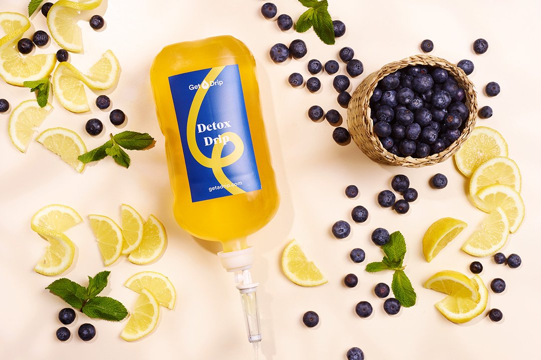 Detox vitamin drip surrounded by berries and lemon