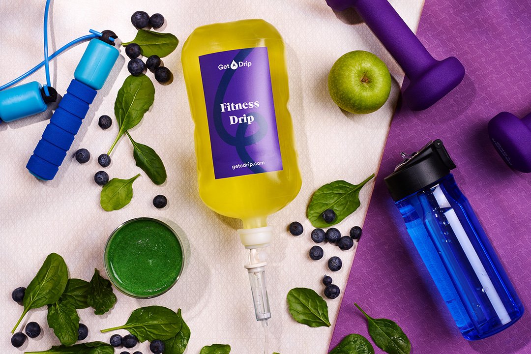 Fitness vitamin drip surrounded by berries and fitness equipment