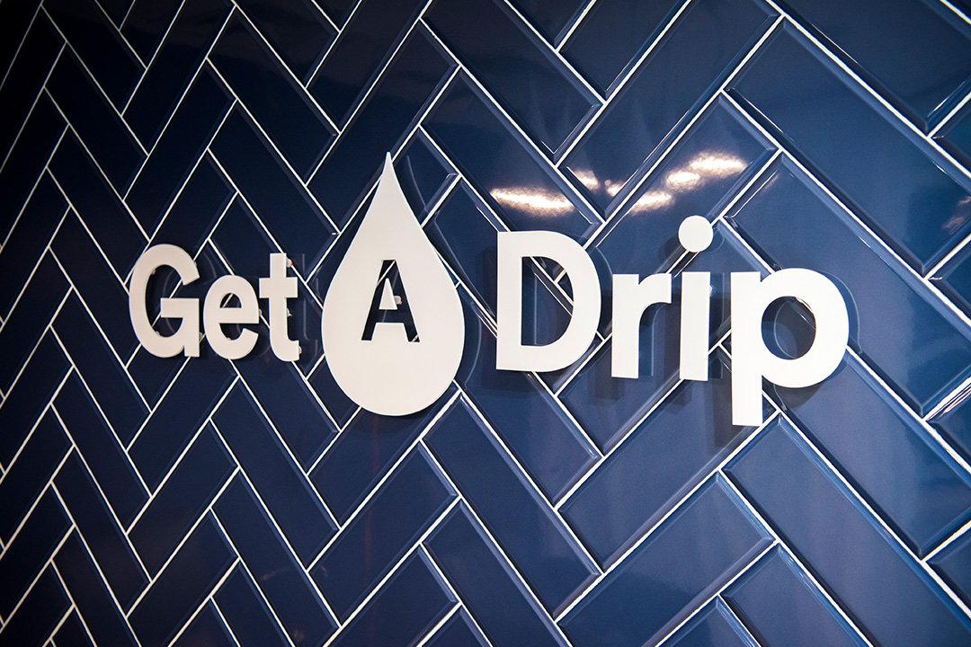 Get A Drip wall sign on a blue panel wall