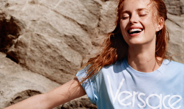 een vrouw draagt een Versace t-shirt met een grote rots op de achtergrond